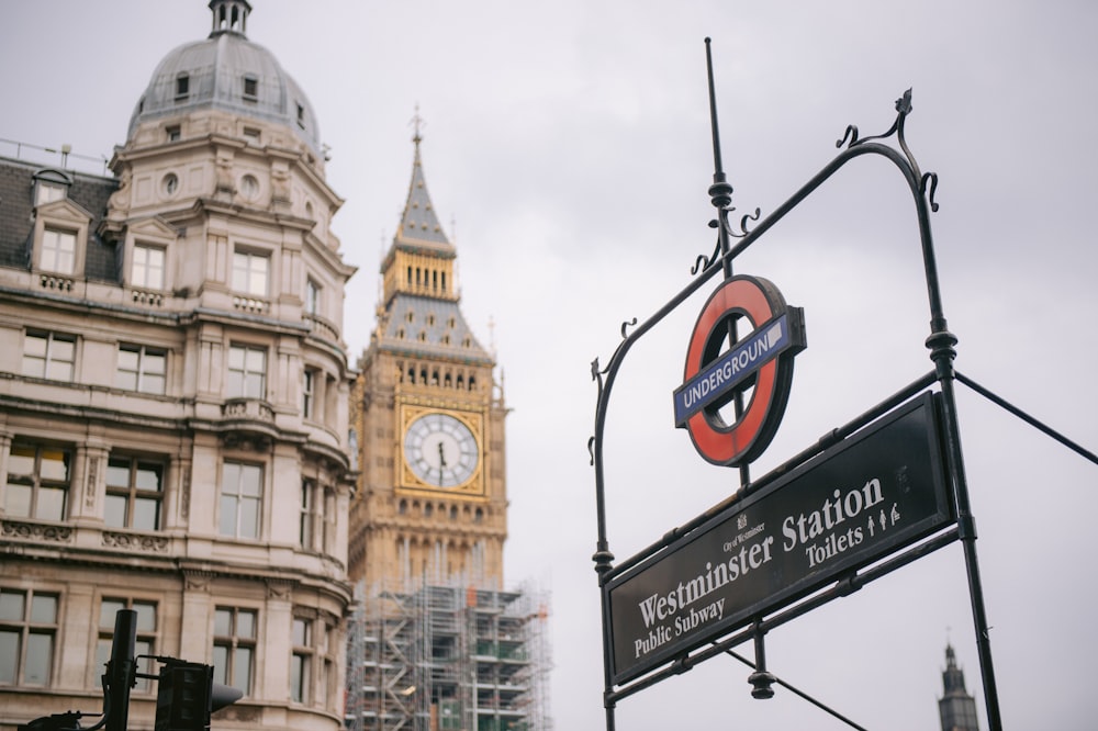 a street sign with a clock tower in the background