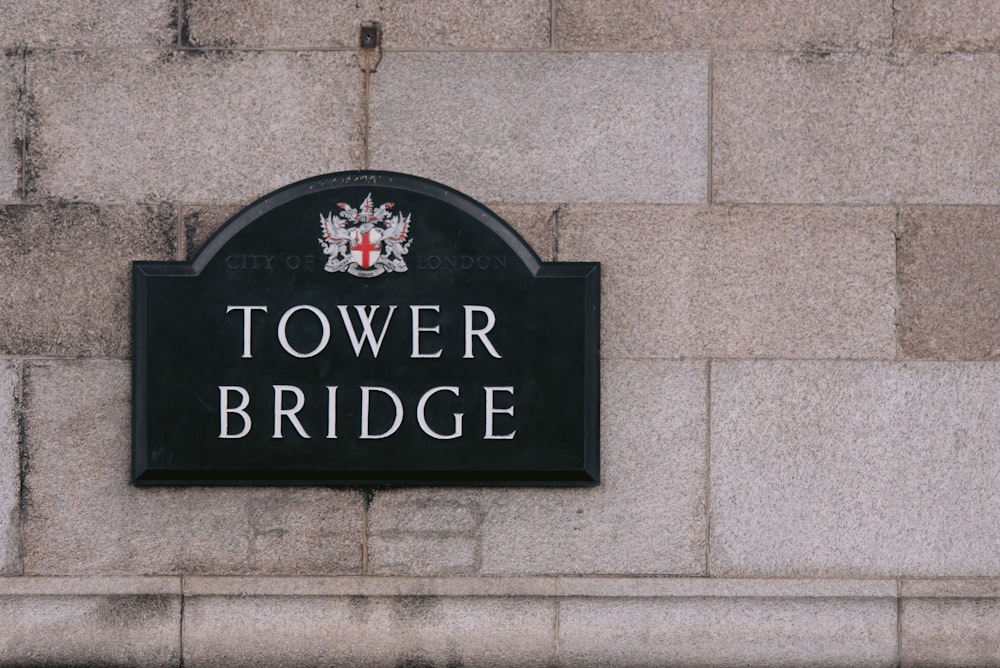 a sign on the side of a building that says tower bridge