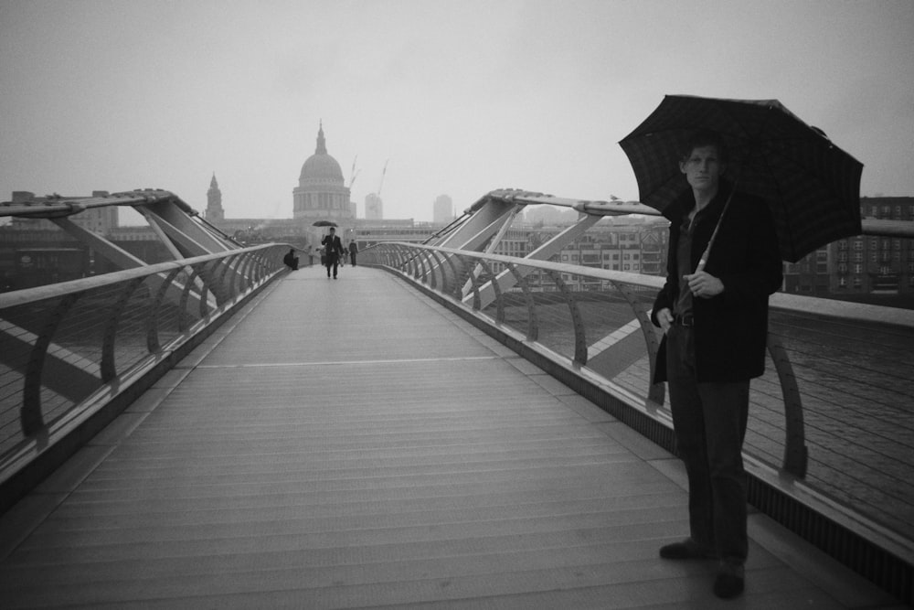 傘をさして橋の上に立つ女性