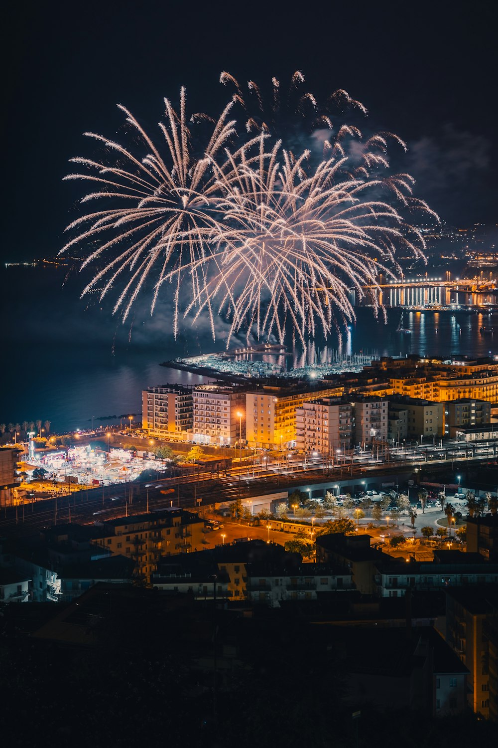 fireworks are lit up in the night sky over a city