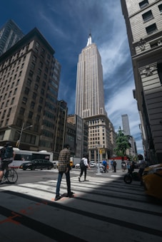 a group of people crossing a street in front of tall buildings
