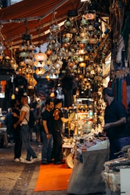 A bustling market street filled with colorful stalls and lively crowds under vibrant lanterns.