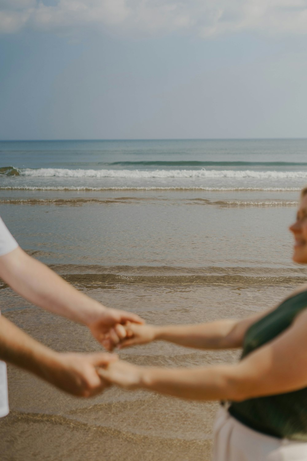 um homem e uma mulher de mãos dadas na praia