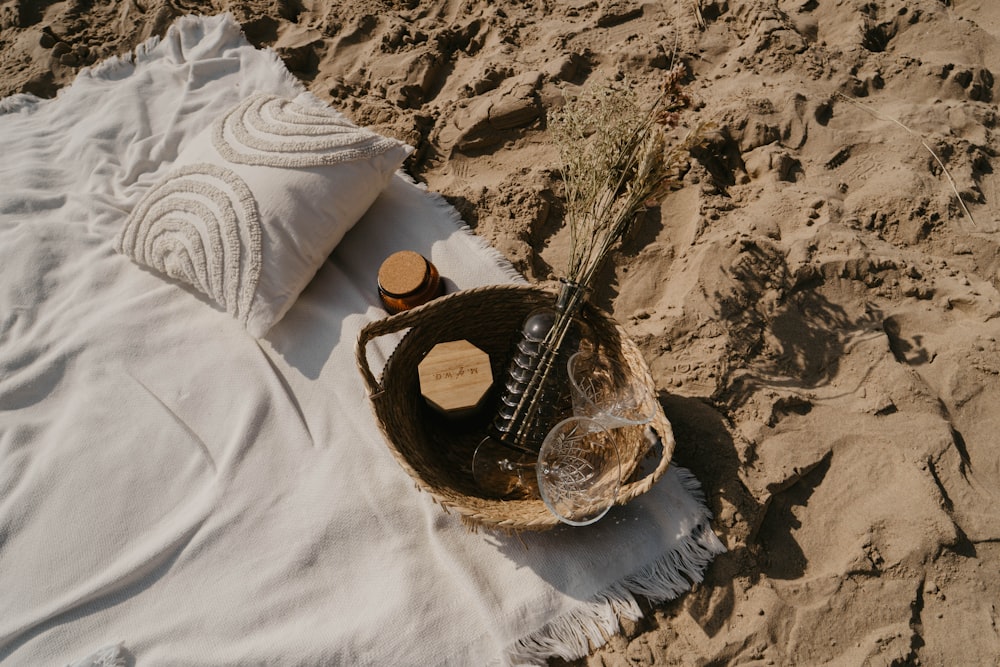 a bottle of wine and a glass on a blanket on the beach