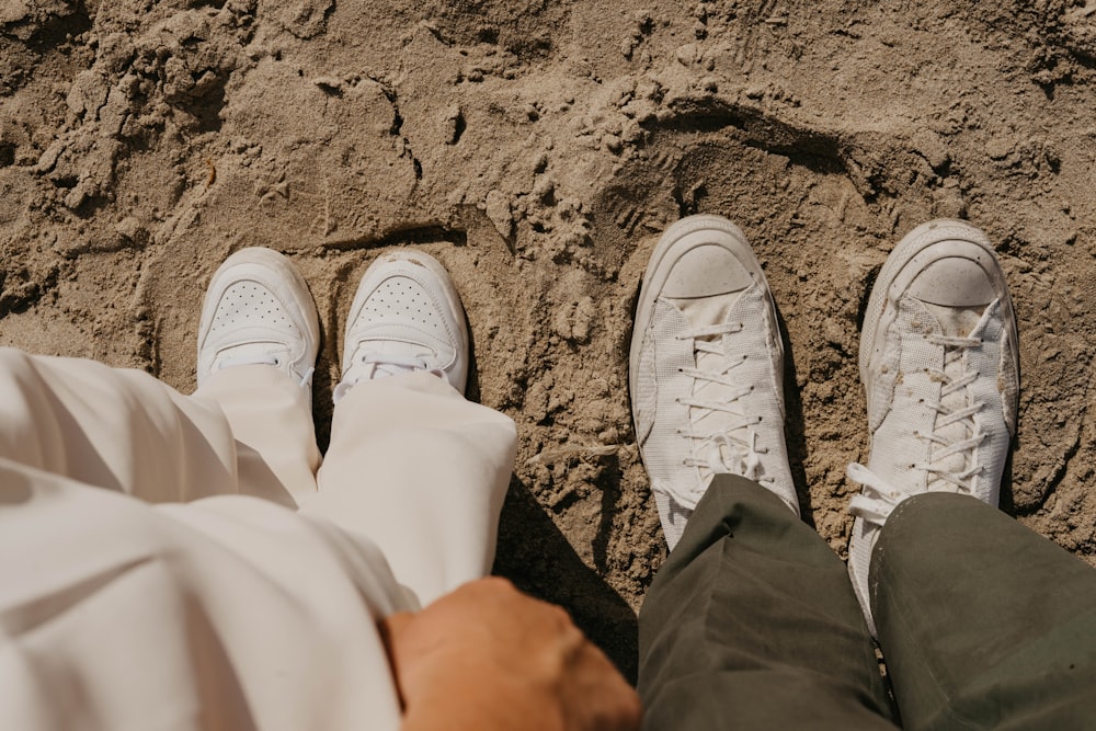 a couple of people that are standing in the sand