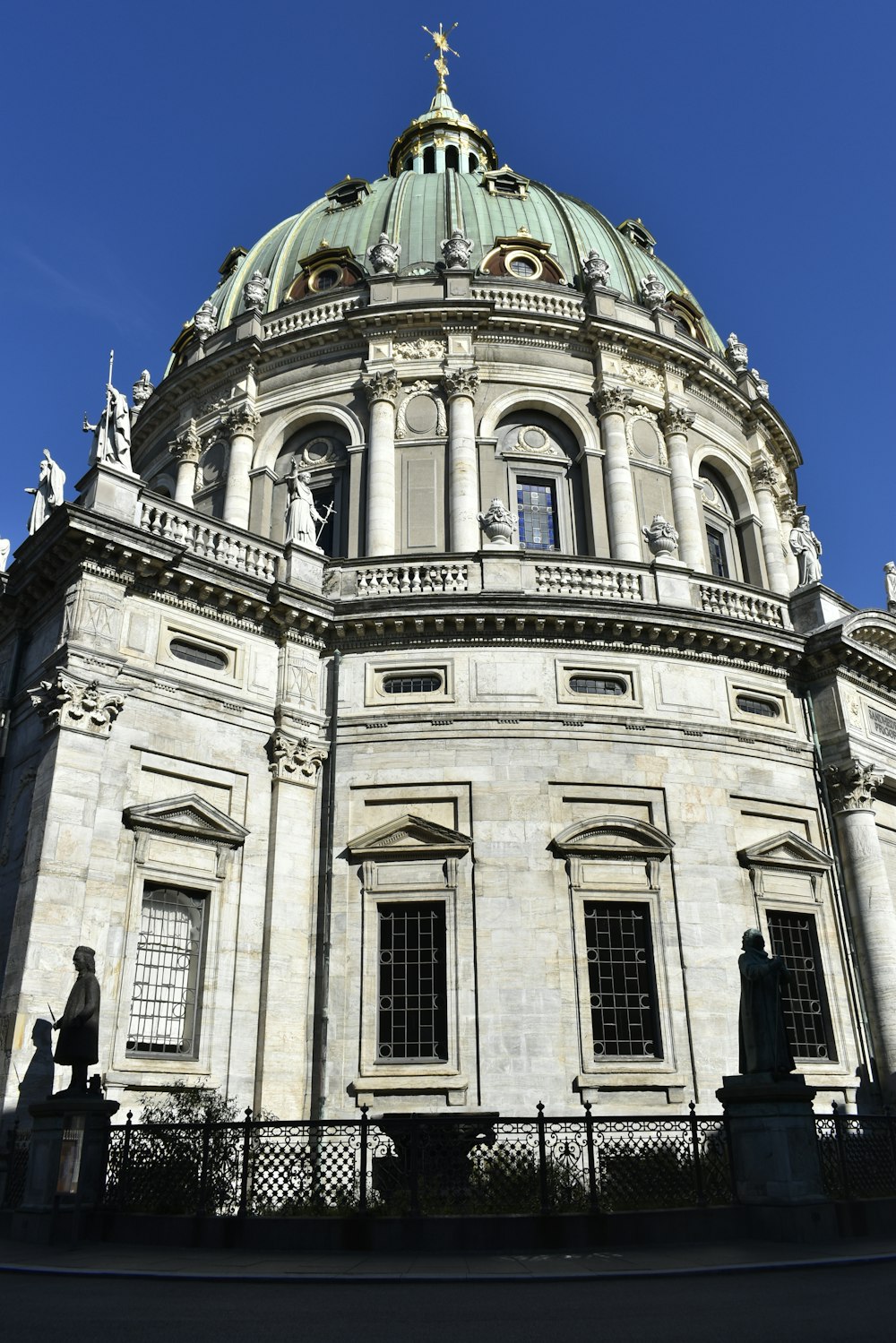 a large white building with a green dome