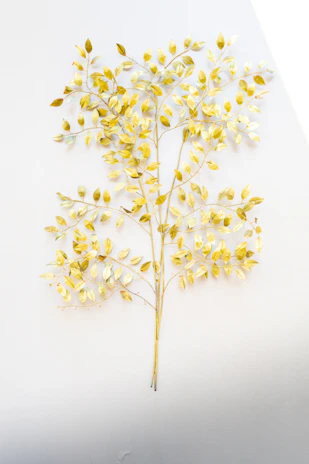 Elegant seasonal artwork featuring muted gold leaves gently falling against a warm ivory background.