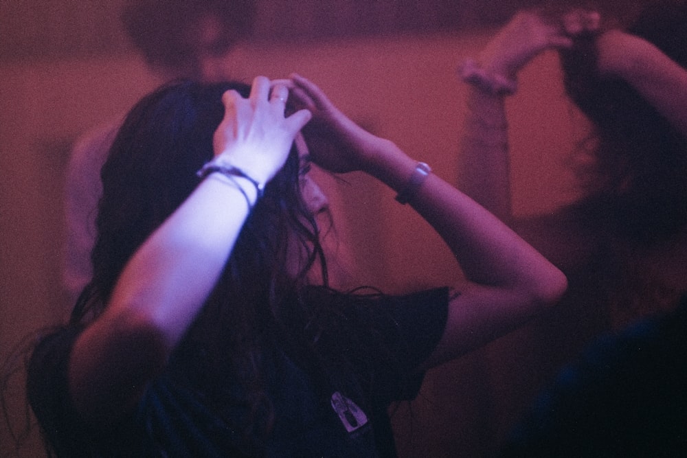 a woman standing in front of a mirror with her hands on her head