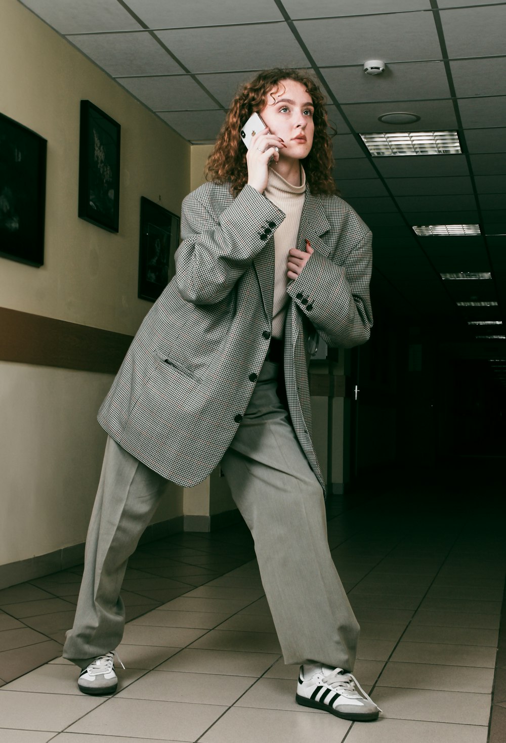 a woman in a suit is talking on a cell phone