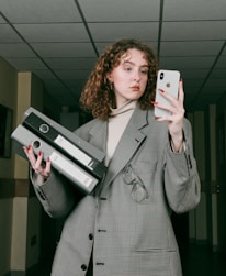 a woman in a suit holding a cell phone