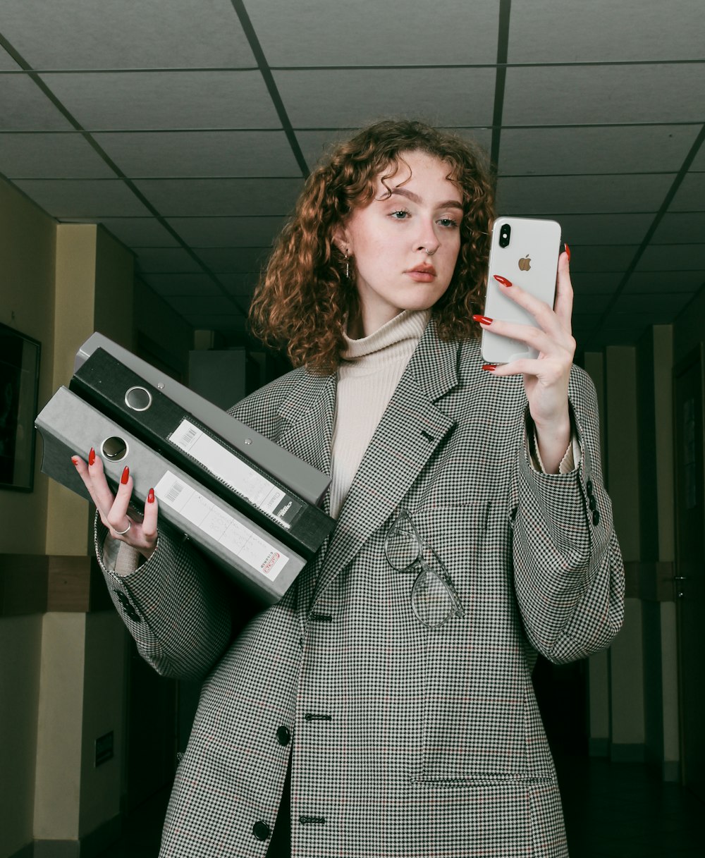 a woman in a suit holding a cell phone