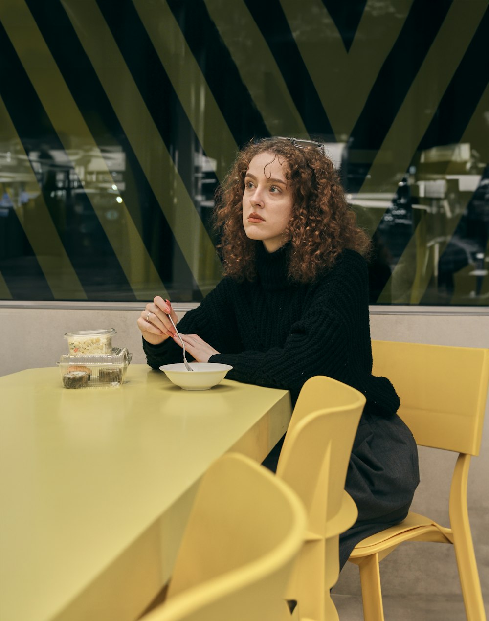 a woman sitting at a table with a plate of food