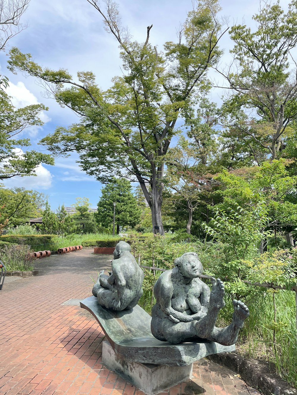 a couple of statues sitting on top of a bench