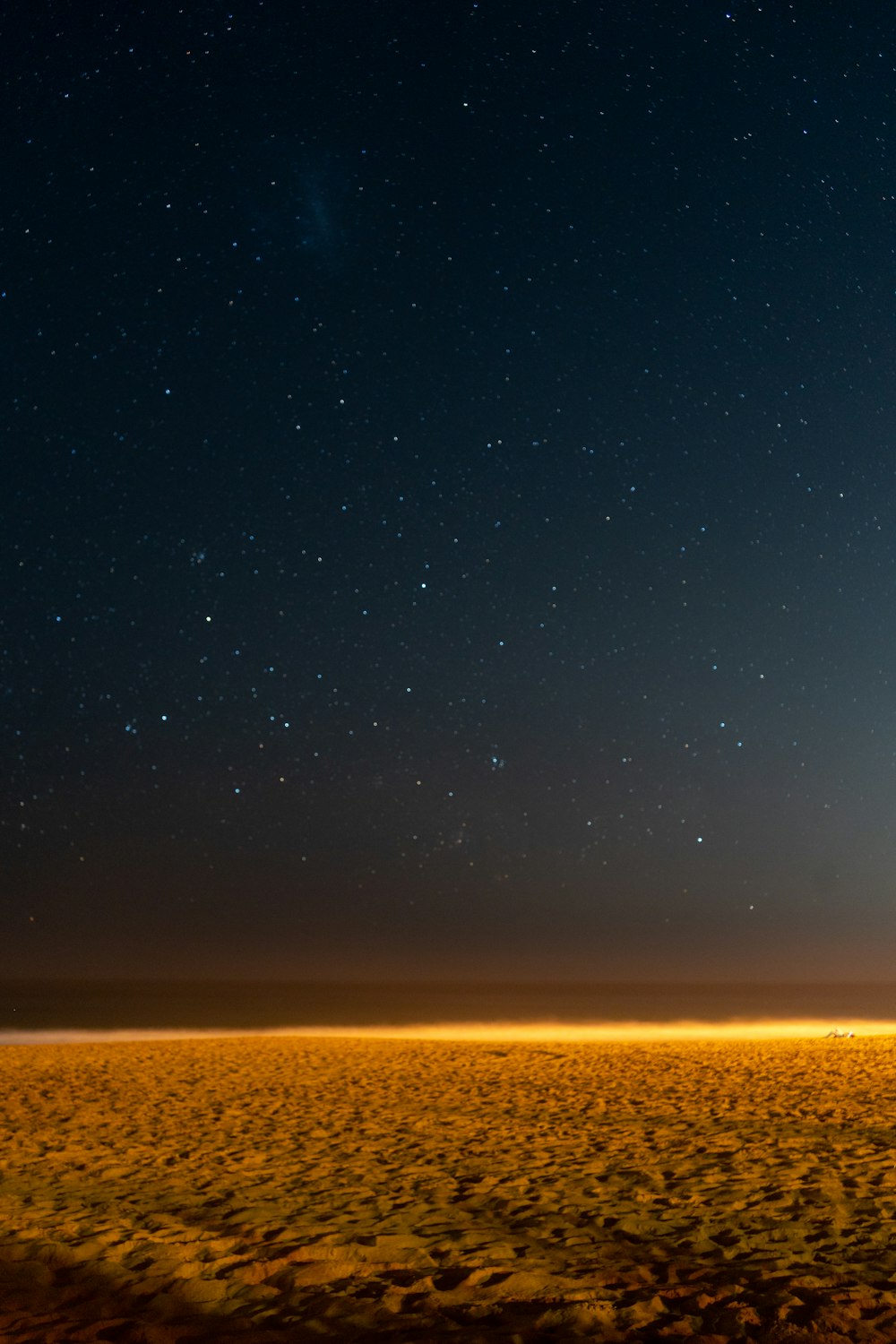 a lone tree in the middle of a field at night