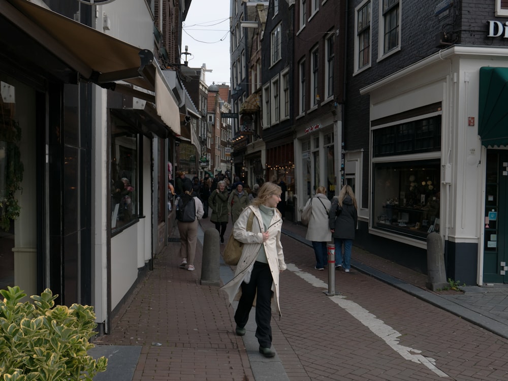 a woman walking down a street next to tall buildings