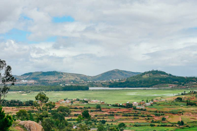 A scenic open plot with fertile land ready for development, framed by distant hills.
