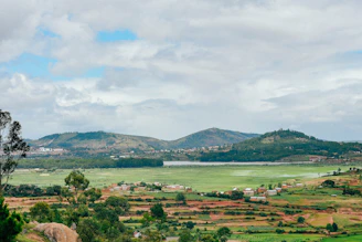 A scenic open plot with fertile land ready for development, framed by distant hills.