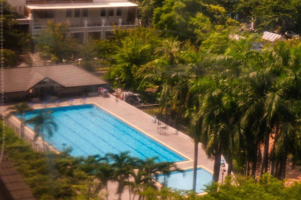 an aerial view of a swimming pool surrounded by trees