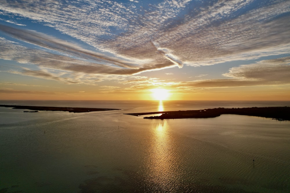 the sun is setting over a body of water