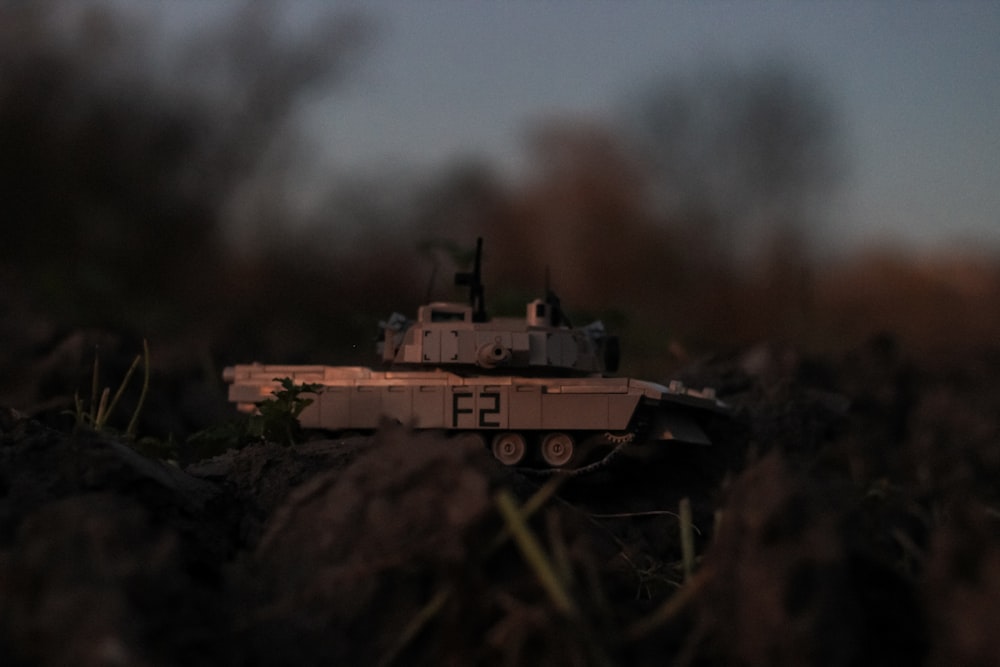 a toy tank sitting on top of a pile of dirt