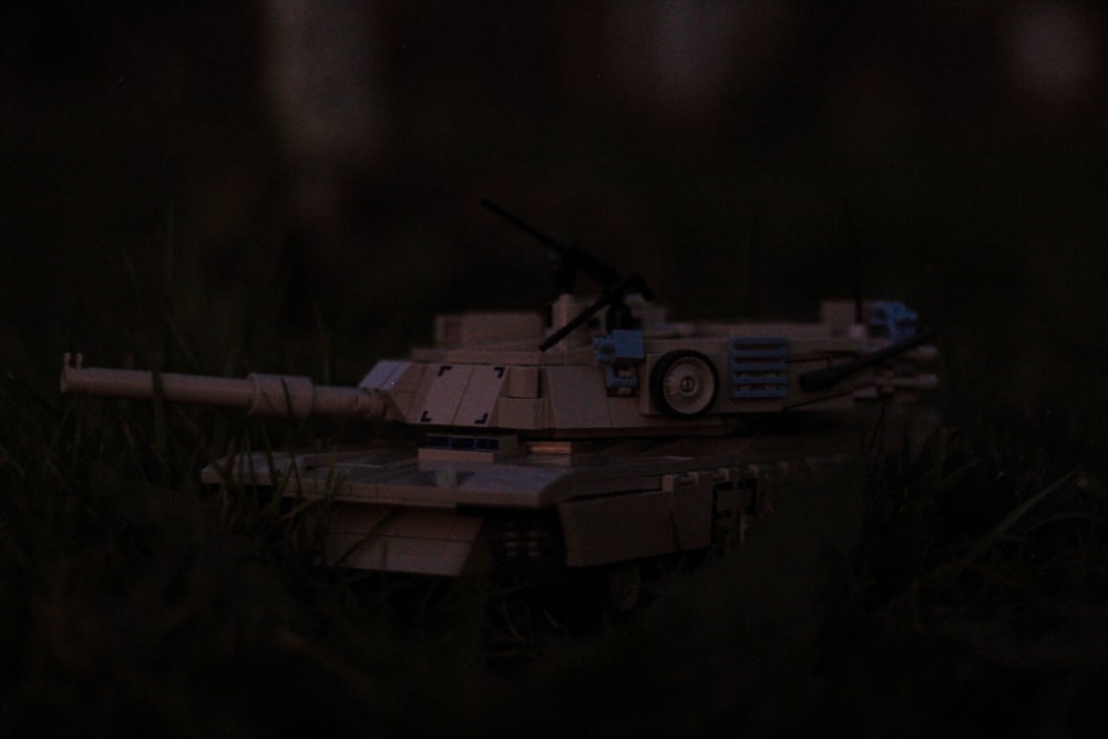 a toy tank sitting in the grass at night