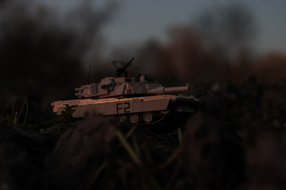 a toy tank sitting in the middle of a field