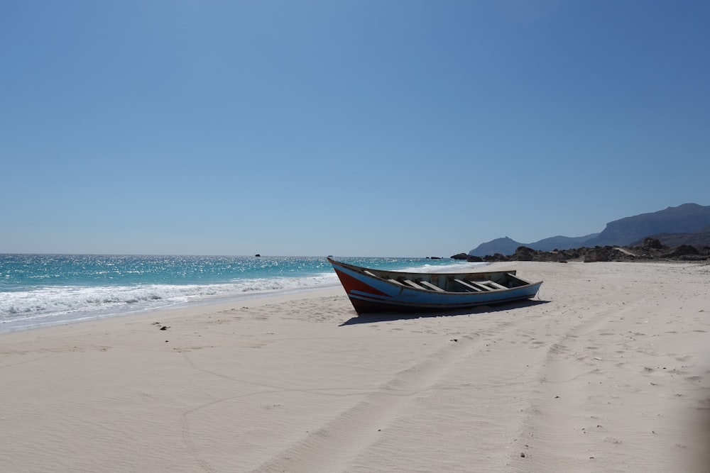 a boat sitting on top of a sandy beach