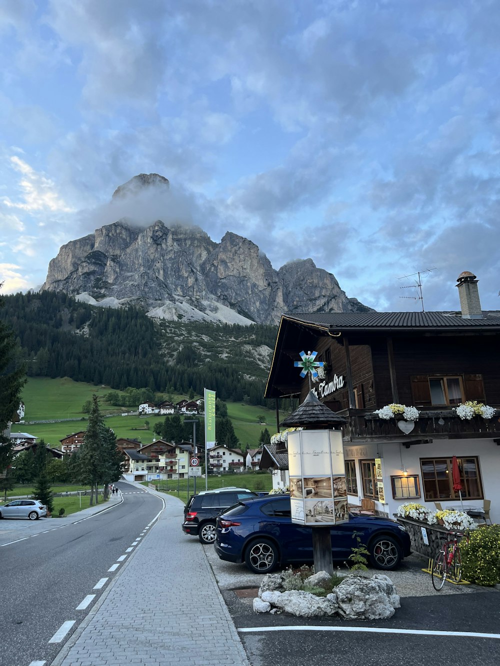 cars parked on the side of the road in front of a mountain