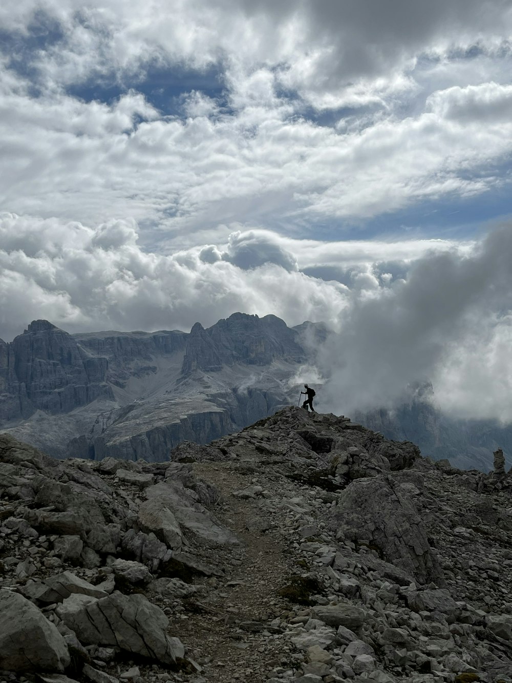 una persona de pie en la cima de una montaña rocosa