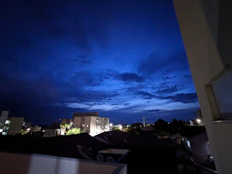 A serene night sky over a calm cityscape bathed in deep blue and gold hues.