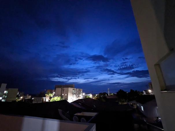 A serene night sky over a calm cityscape bathed in deep blue and gold hues.