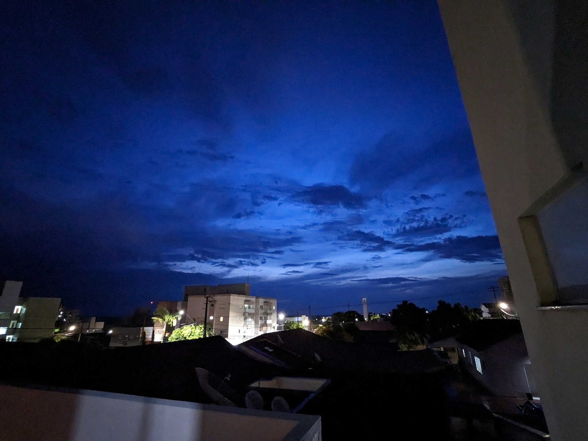 An artistic shot of a city skyline at night, with glowing lights contrasting against a deep blue background.