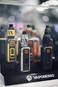 Variety of vape devices and cannabis products displayed on a shelf.