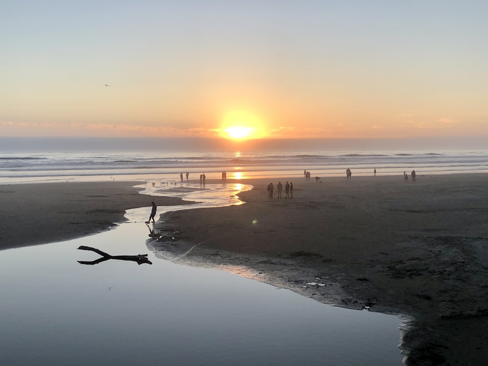 a group of people standing on top of a beach