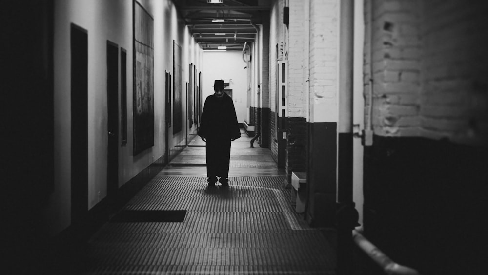 a person walking down a hallway between two buildings