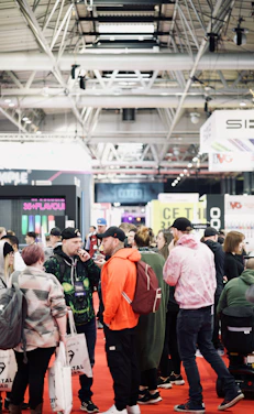 Panoramic view of a bustling international trade show with vibrant booths and diverse business professionals engaged in discussions.