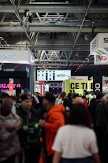 Craftsmen assembling a custom exhibition stand on a busy trade show floor.