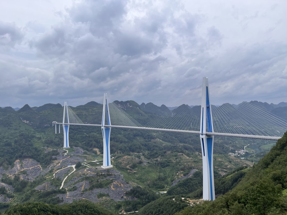 a very tall bridge over a lush green hillside