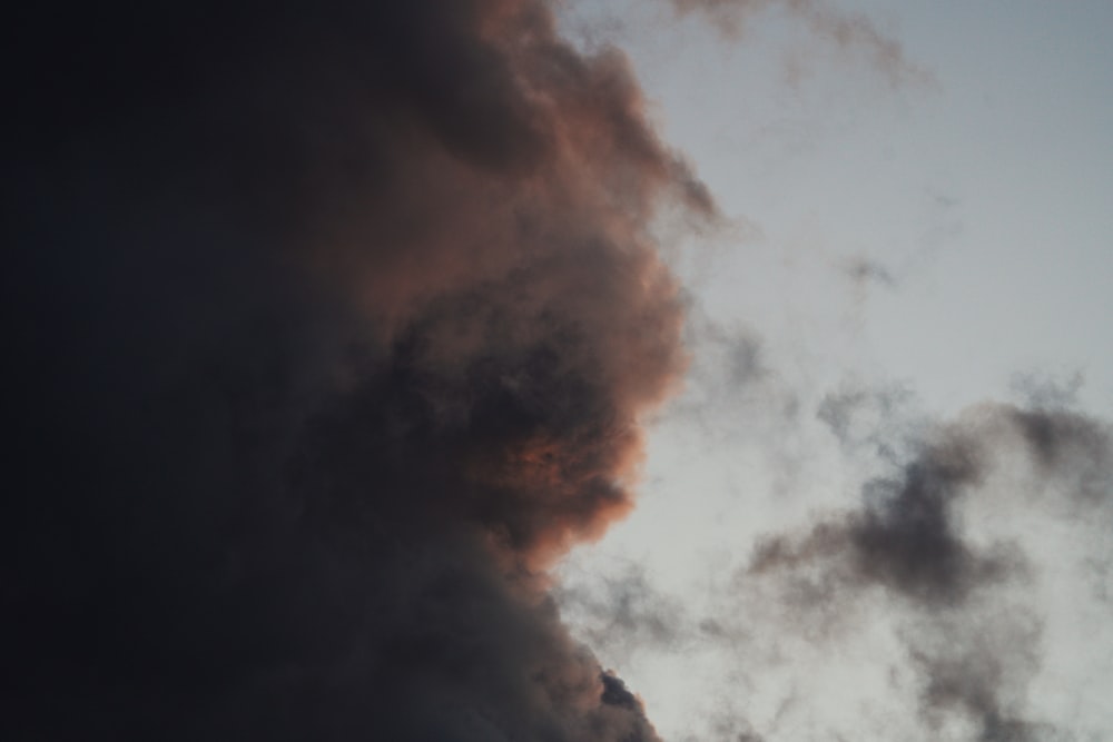 a plane flying in the sky with a lot of smoke coming out of it