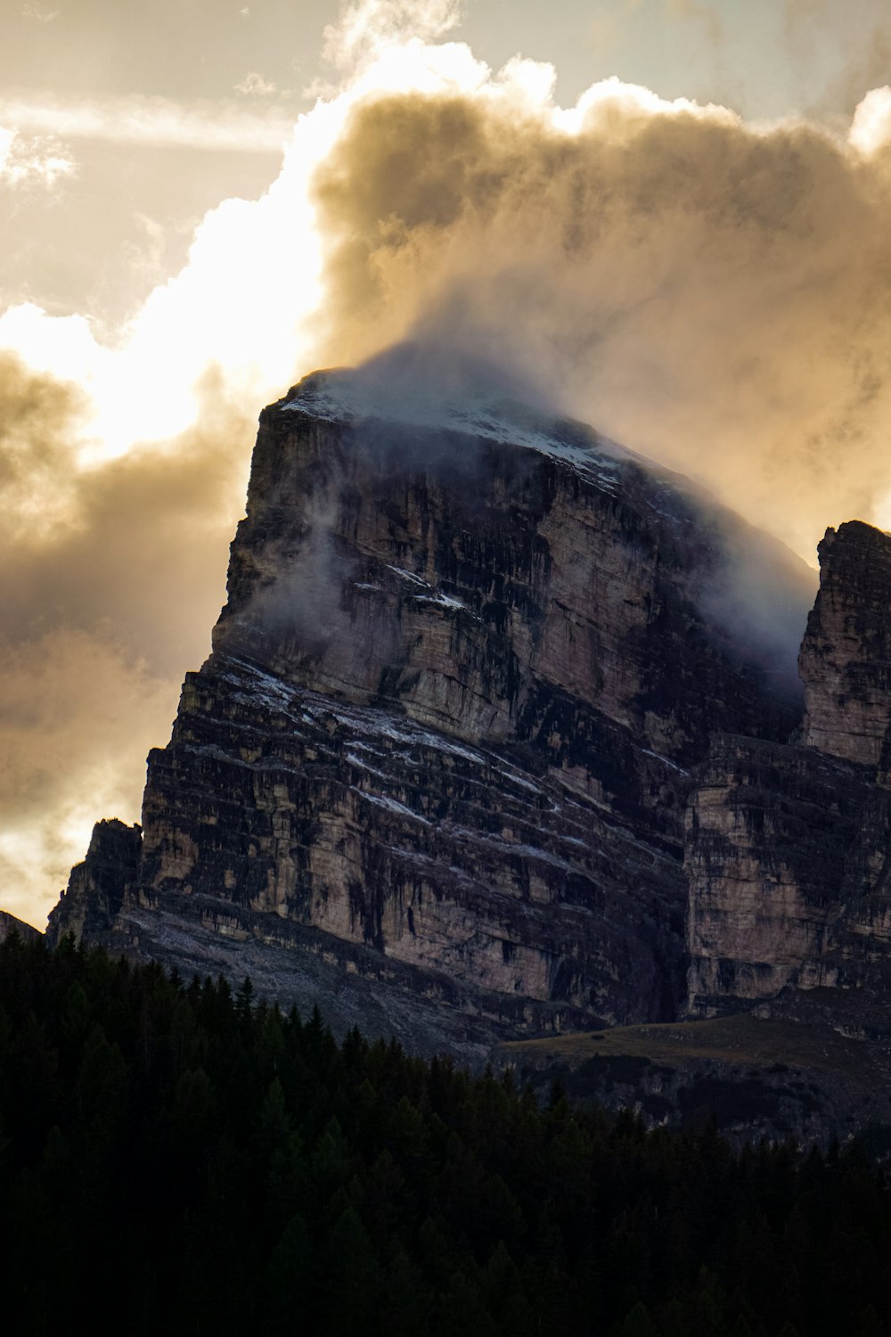 a very tall mountain with some clouds in the sky