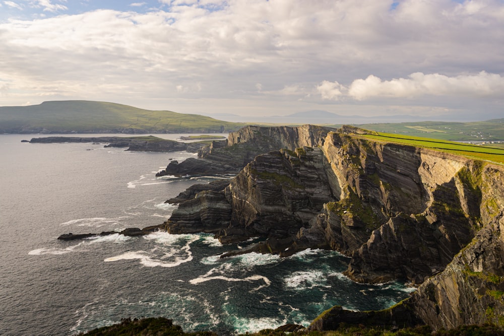 a large body of water next to a rocky cliff