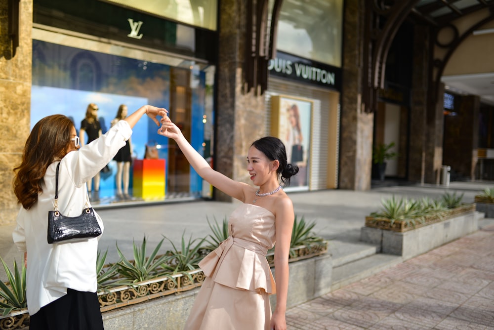 a woman in a pink dress and a woman in a white jacket