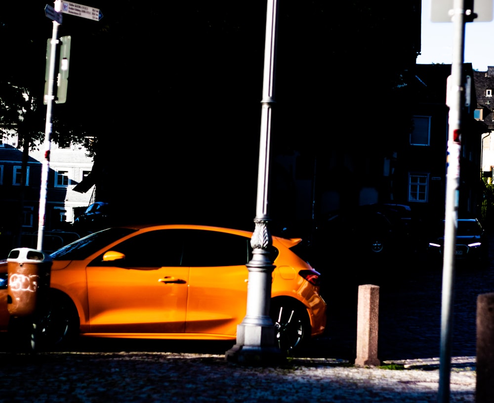 un'auto arancione parcheggiata sul ciglio della strada