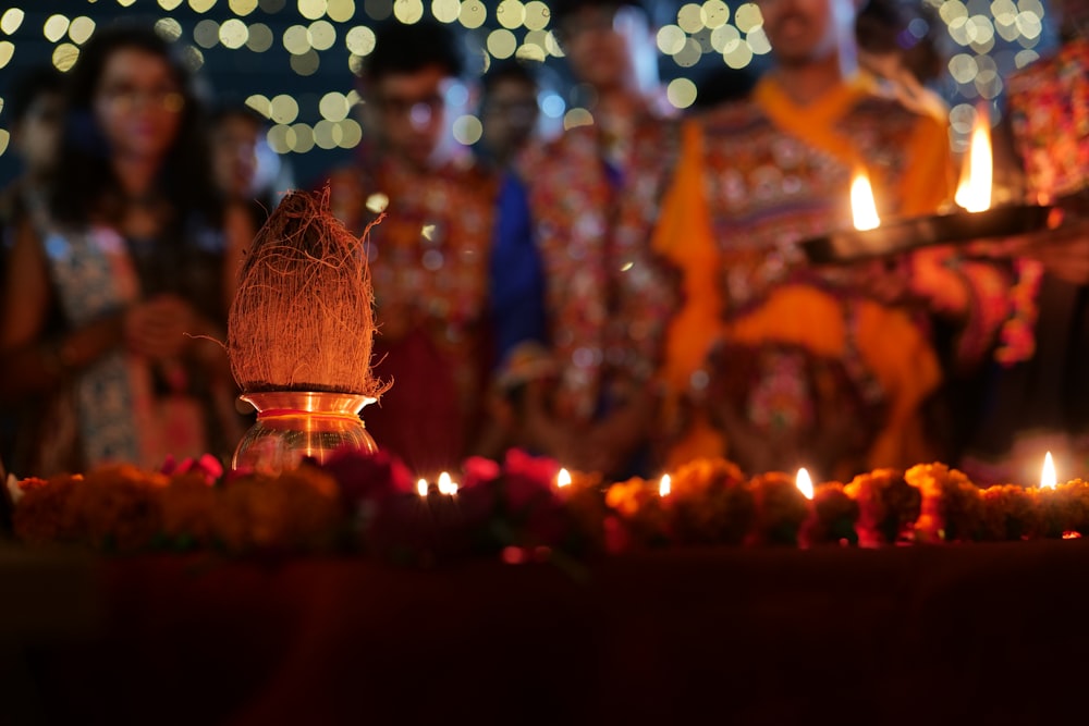 a group of people standing around a table with candles