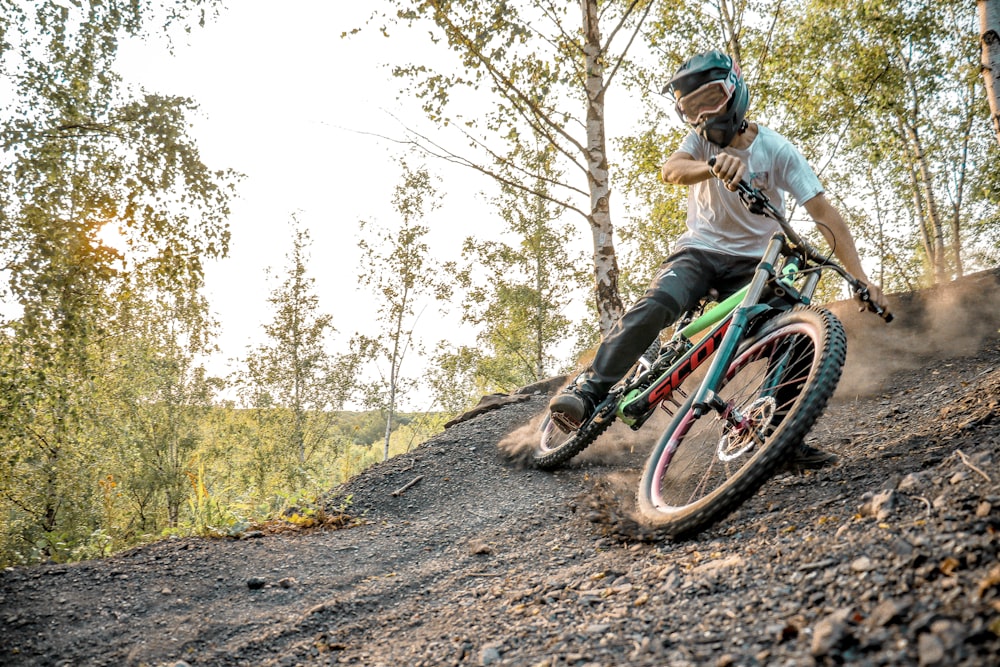 a man riding a bike down a dirt road