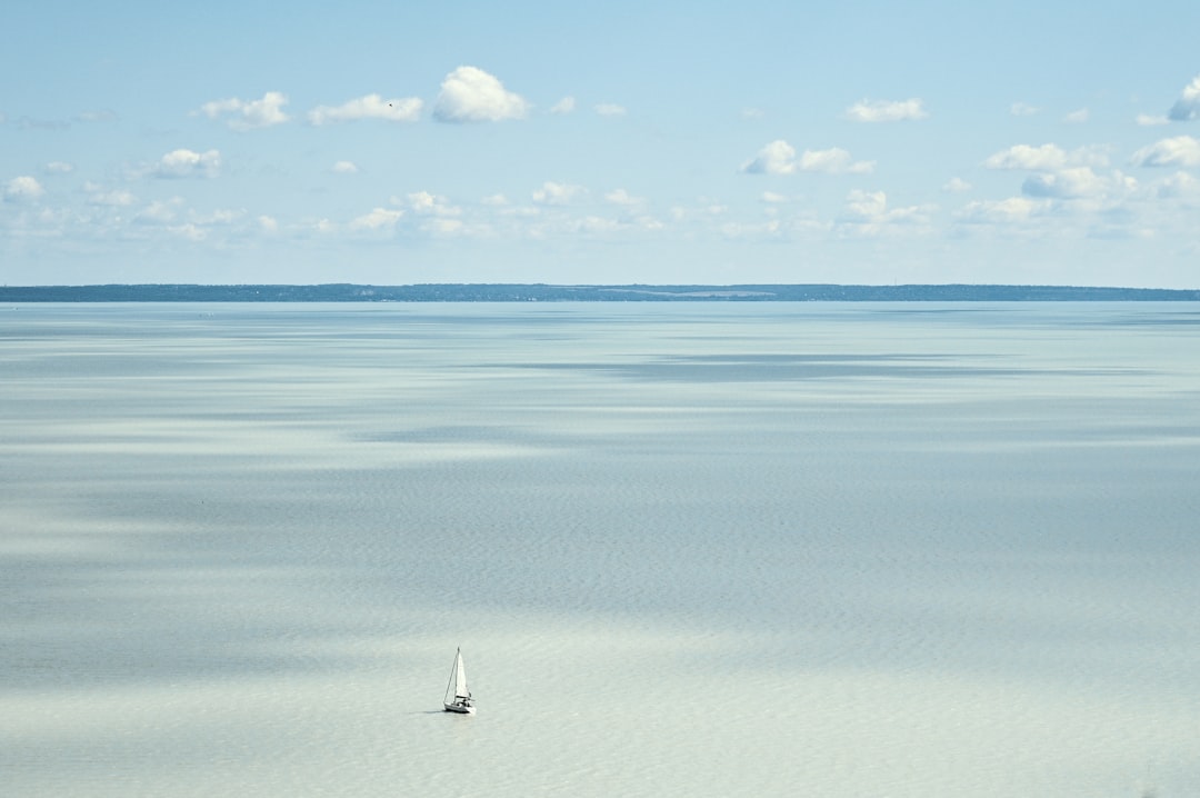 a lone sailboat in the middle of a large body of water,