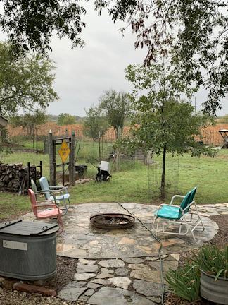 A beautifully crafted stone patio with a fire pit surrounded by vibrant plants.