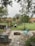 A beautifully designed stone patio with integrated fire pit surrounded by lush greenery.