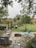 A beautifully designed stone patio with integrated fire pit surrounded by lush greenery.