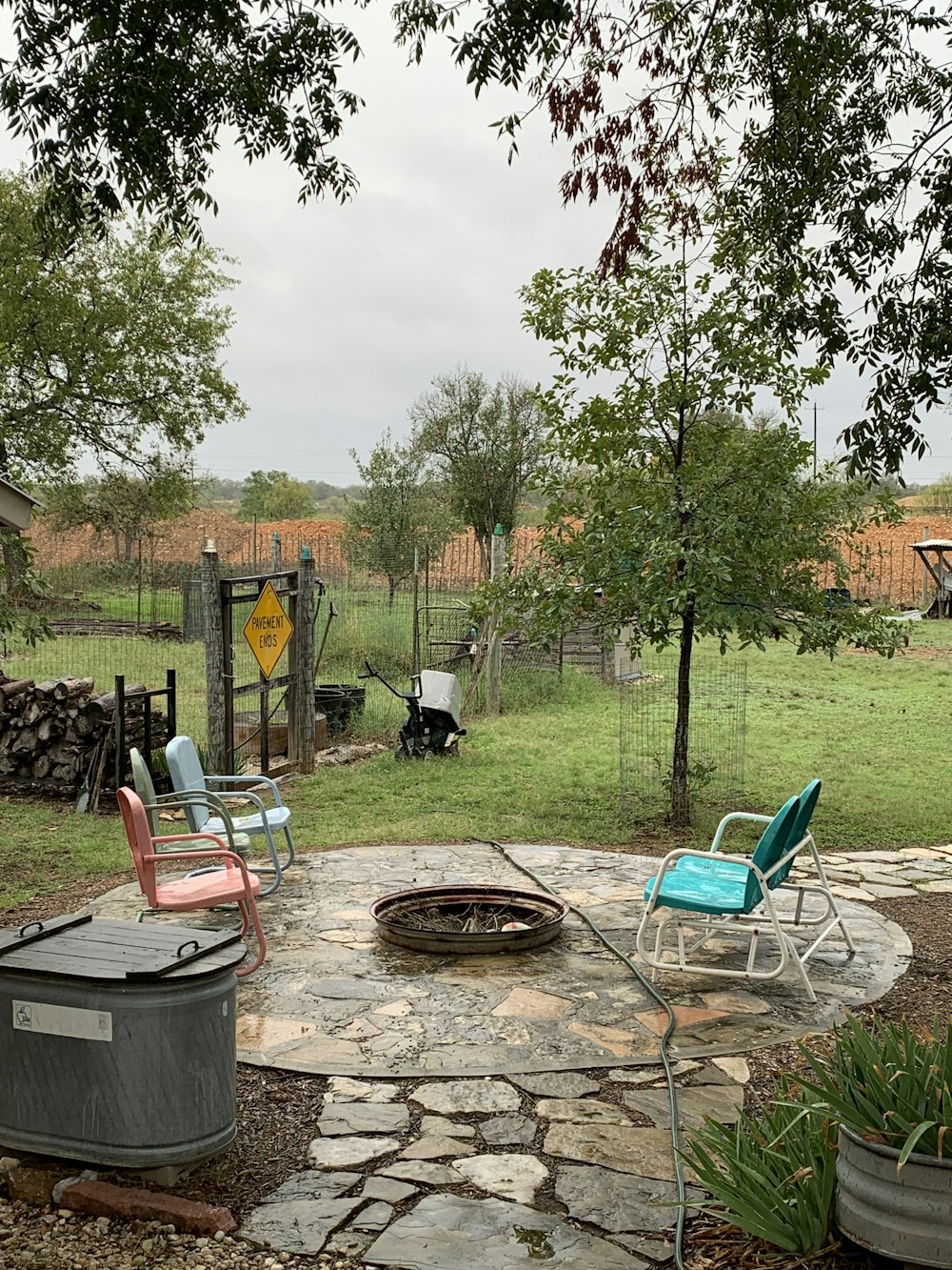 a backyard with a fire pit and chairs